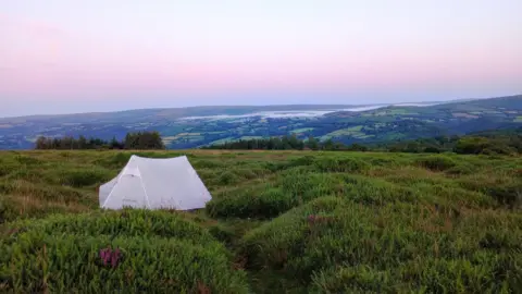Becky Harrison A white tent has been pitched up in an empty field on Dartmoor.