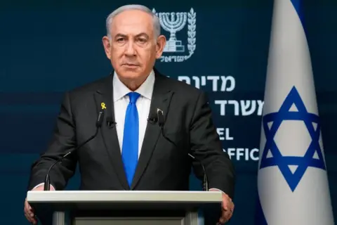 EPA Benjamin Netanyahu stands at a lectern with an Israeli flag to his left