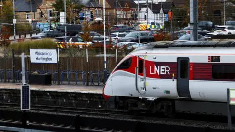 Reuters A train is seen stationary at Huntingdon station. A police van is in the background.