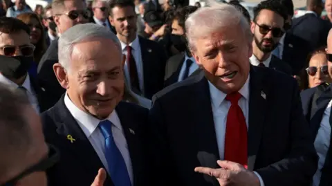 Reuters Donald Trump points to Israeli Prime Minister Benjamin Netanyahu. They are standing next to each other at the Ben Gurion International Airport ahead of Trump's visit to Egypt for the summit