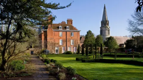 A general view of Welford Park, a stately home with a chapel to the right of it and a large lawn