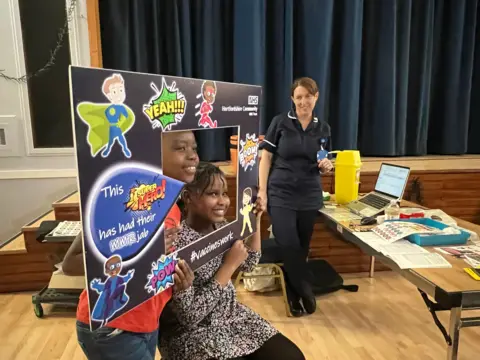 Emma Baugh/BBC Vaccination clinic with a celebration sign