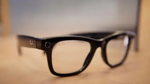 A set of black Meta Ray-Ban smart glasses on a table.