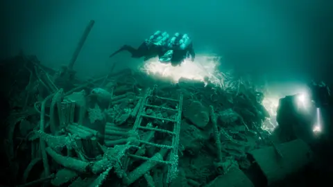 Divers documenting the bow section of the wreck of a Royal Navy warship 