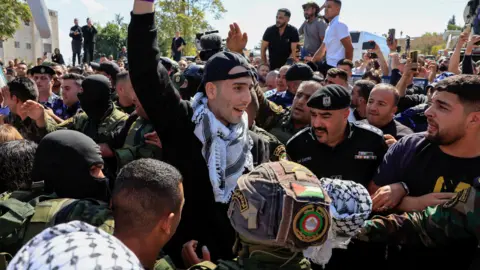 Reuters A prisoner holds his hands in the air after release. 