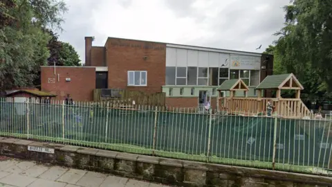 Exterior view of Early Learners Day Nursery building showing play area in front behind fencing