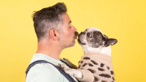 A man kissing his dog