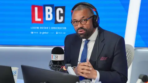 PA Media Home Secretary James Cleverly takes part in a debate on LBC