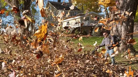 Getty Images Leaves fly everywhere as a man uses an leaf blower