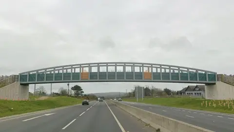 A road view of the Chiverton Cross bridge spanning the dualled A30 in Cornwall. It features a slightly domed over-rail, plus metalwork in yellow and turquoise paint.