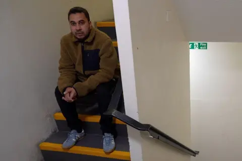 Gaz Rahman on steps in his apartment block