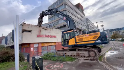 Heavy machinery demolishes a wall at the derelict Anglia Square shopping precinct in Norwich