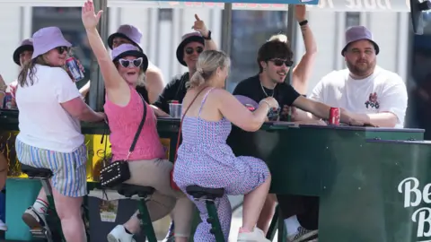 Eddie Mitchell A group of people enjoy the "Brighton Bike" wearing hats and sunglasses