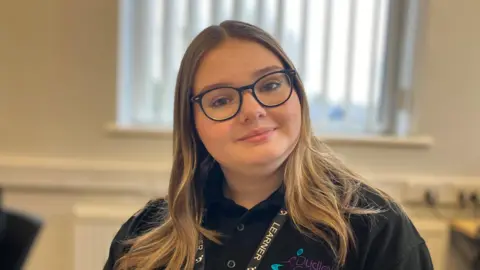 Lacey, 16, sits in a classroom at Dudley College