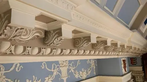 Colchester City Council Part of an ornate ceiling. It is mainly blue and cream with plasterwork flowers in vases inlaid