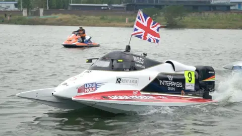 Jelf Racing A red and white powerboat on grey water. The boat has a Union Jack on the top