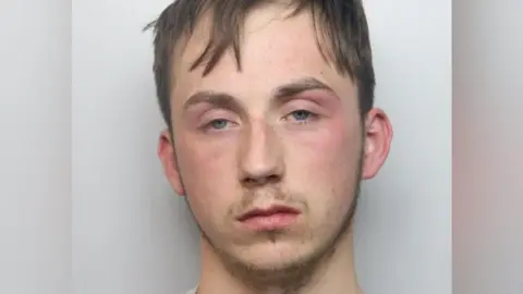 Northamptonshire Police A mugshot of Sutton, who has brown hair and facial hair