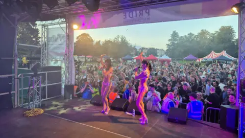 Pride in Gloucestershire The Cheeky Girls onstage with their hands in the air performing to a crowd in a field