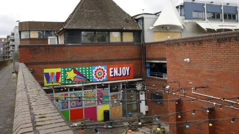 Facundo Arrizabalaga Watermans Arts Centre, a brick building with bright paint and fairy lights