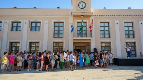 Europa Press A group of people holding placards listen to a person making a speech