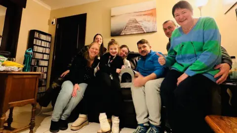 Family handout Rudolf Szentimrey with his wife Anita, seven-year-old daughter Noemi and kitten Mancs who is in a basket. Members of the foster family that took case of the kitten.