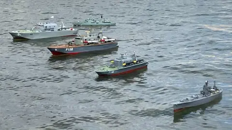 Redcar Model Boat Club Five grey model ships of different sizes sailing in a section of the lake on Friday, 6 June.
