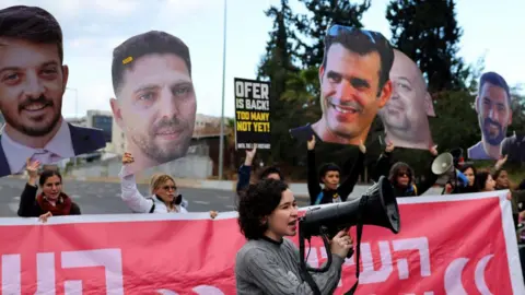 AFP Relatives and supporters of Israeli hostages held by Hamas in Gaza take part in a protest a calling for the release of all hostages, on a highway in Tel Aviv, Israel (13 February 2025)