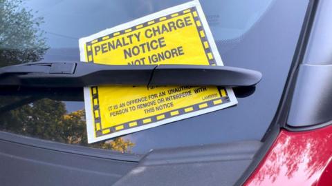 A penalty charge notice on a car windscreen