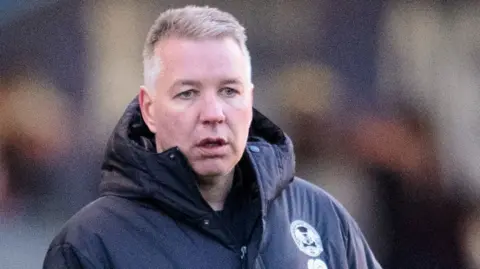 Getty Images Profile picture of Darren Ferguson wearing a black coat with a blurred out background. 