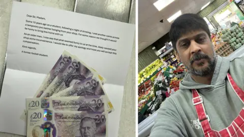 Imran Ashraf Five £20 cash notes in GBP are spread out over a piece of paper used as a letter. On the right is a man with a beard, grey hoodie and red apron stood behind fruit and vegetables in a supermarket.