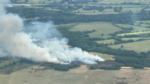 Matthew Coates An aerial photo showing plumes of smoke billowing from fields.