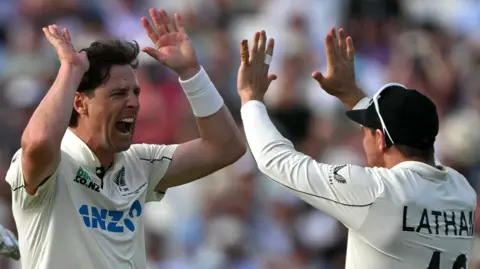 New Zealand bowler Matt Henry (left) celebrates taking a wicket with captain Tom Latham (right)