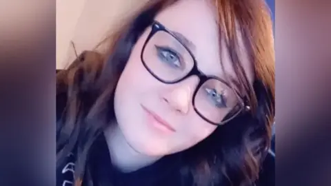 CONTRIBUTED Courtney Morgan, who is wearing glasses with large black frames and has long, dark, hair looks at the camera in a selfie-style shot.