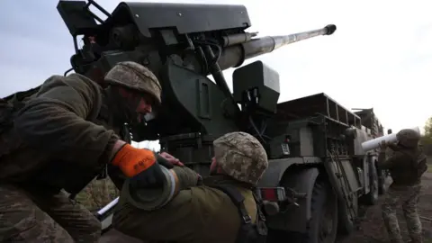 Ukrainian soldiers use a Howitzer