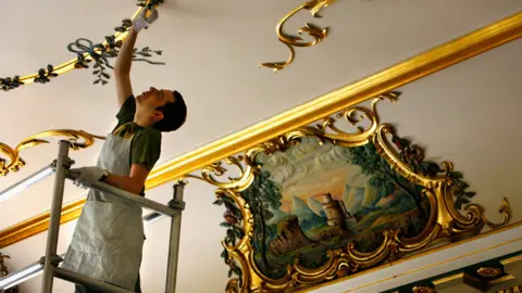 Getty Images John Morrison inspects the ceiling in the entrance hall to Dumfries House before it was first opened to the public in 2008