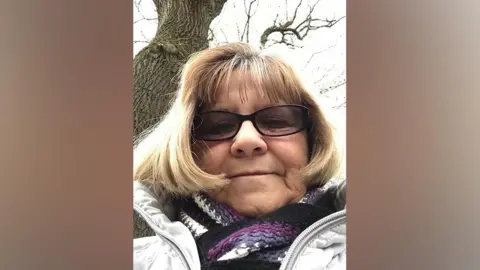 Handout A selfie of an older woman wearing a purple stripey scarf and glasses. 