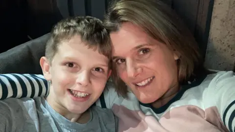 PA Media Ellen Roome and her son Jools. She has brown hair and eyes and is wearing a striped top. Jools has a grey t-shirt on and brown hair.