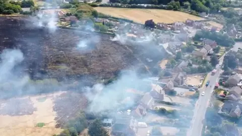 Matt Banks Drone footage of large plumes of smoke after a wildfire scorched a field in Harvington