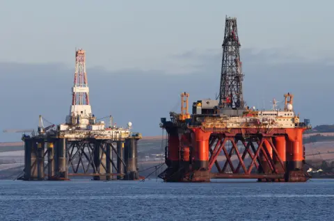 PA Media Two defunct oil rigs in the Cromarty Firth