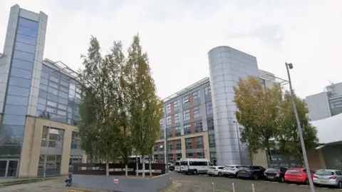 Doncaster College, on Chappell Drive. There are parked cars to the right and trees in the centre.