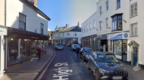 Google The high street in Sidmouth. There is a one way street with shops pictured either side of the road.