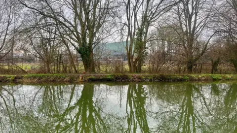 A view of the incinerator in the distance with Exeter Canal in the foreground  and the site of the planned energy centre between the two.