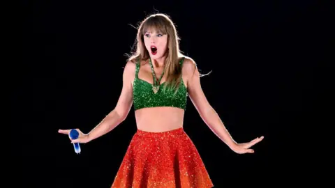 Getty Images Taylor Swift dressed in red and green at the Cardiff concert