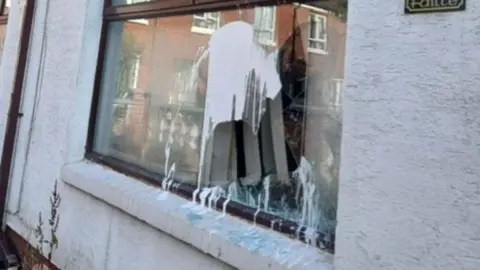 A white house with pain on the window