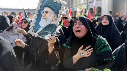 A woman weeps as people gather at the Imam Khomeini Grand Mosalla for a farewell ceremony for Iran's late Ayatollah Ali Khamenei