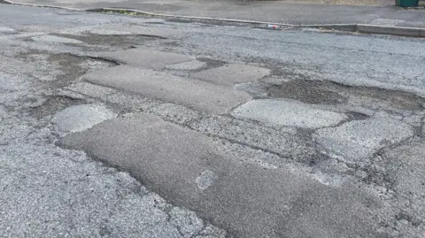 An image of potholes and filled potholes in a road in Digby Road, Mapperley, Nottingham