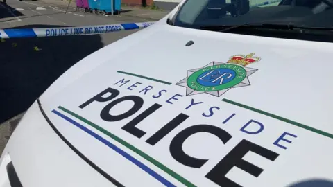 Close up of the bonnet of a Merseyside Police car with the logo across it.