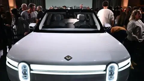 Getty Images People look at the new Rivian R2 electric vehicle at the Rivian South Coast Theatre in Laguna Beach, California, on 7 March, 2024.