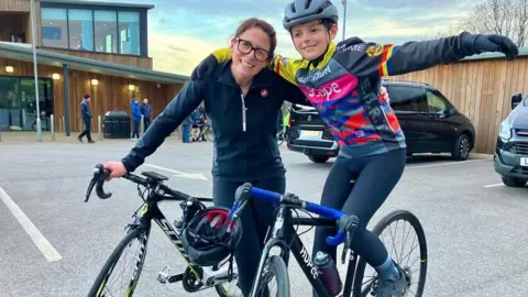 Family handout A woman on a bike with her arm around a boy who is also on a bike. 