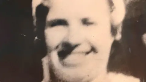 University of Edinburgh Blurred black-and-white picture of Mary Rogerson, who is smiling as she poses for the camera.